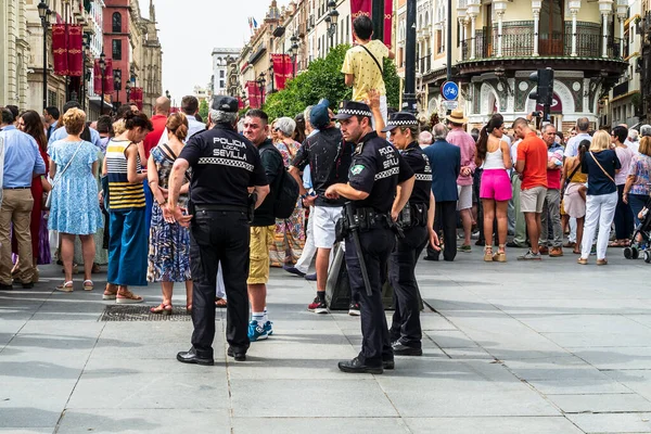 Seville, Spain -- June 6, 2022. Police Officers guard the route as people gather for the Corpus Christi procession.