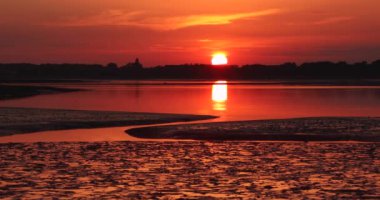 Setting sun over Pagham Harbour and nature reserve, West Sussex, South UK.