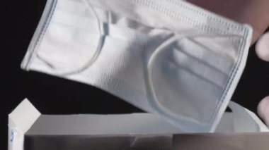 Kutudan yüz maskesi kalitesini kontrol ediliyor