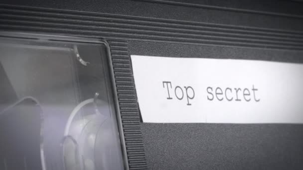 Close-up shot van een vhs cassette mechanisme met een topgeheim bordje erop. — Stockvideo
