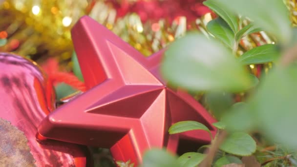 Mirada más cercana de la estrella roja de Navidad y bolas en el suelo — Vídeo de stock