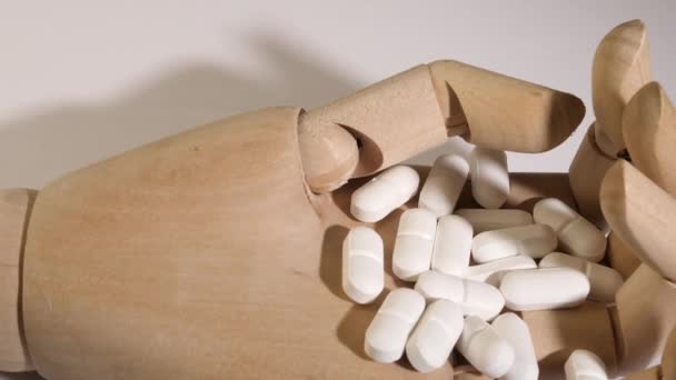 Close-up shot van witte pillen op een mannequin hand. — Stockvideo