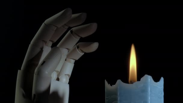 Крупный план горящей свечи вращающейся и жуткой руки манекена. — стоковое видео