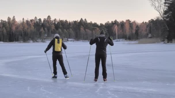 Hermosa toma de patinadores en el mar congelado durante un día soleado. — Vídeos de Stock