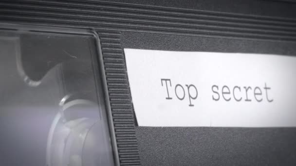 Närbild skott av en fungerande vhs kassett med en topphemlig skylt på den. — Stockvideo