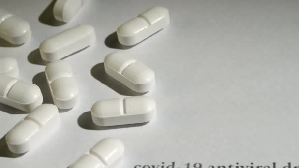 Close-up shot van witte pillen op witte achtergrond. — Stockvideo