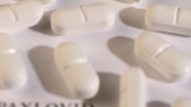 Close-up shot van witte tabletten op witte achtergrond en zwarte tekst. — Stockvideo