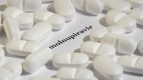 Witte tabletten op witte achtergrond met zwarte tekst. — Stockvideo