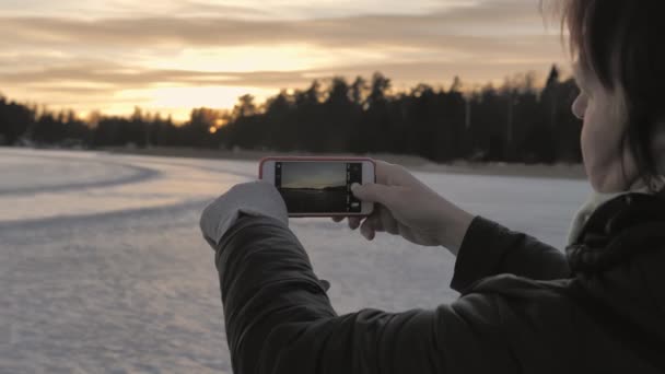 Close-up tiro de uma senhora tirar uma foto do pôr do sol com seu smartphone. — Vídeo de Stock