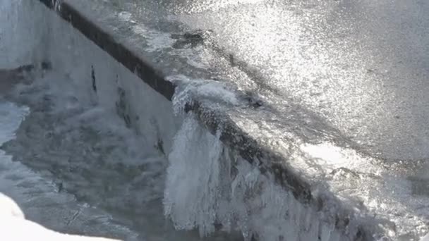 Tiro mais próximo de água congelada que flui sobre uma pequena barragem. — Vídeo de Stock