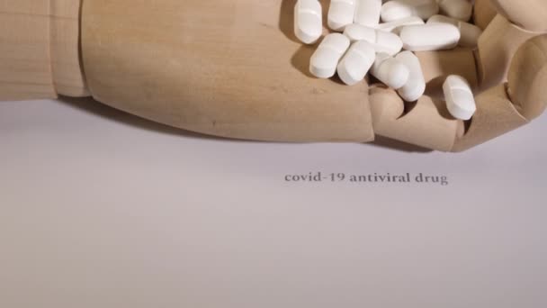 Closeup shot of pills on a wooden mannequin hand. — Video Stock