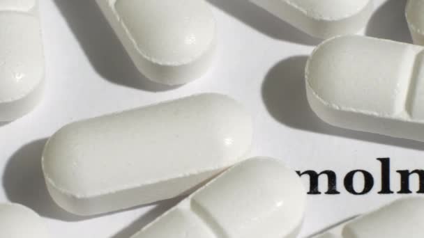 Белые таблетки на белом фоне с черным текстом. — стоковое видео