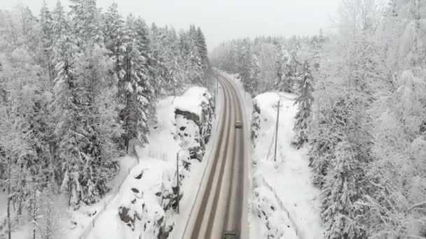 Bliższy widok z powietrza śnieżnej drogi i otaczających ją skał. — Wideo stockowe
