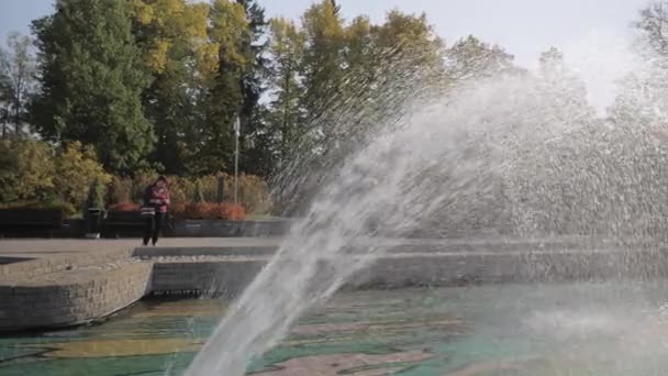 A lady on the side of the big water fountain.4k — kuvapankkivideo