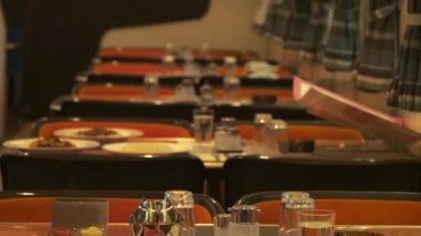 Tables inside of a restaurant wagon of a train.
