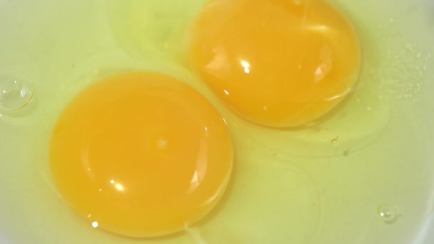 Два треснувших яйца на миске с sugar.close-up.4K UHD — стоковое видео
