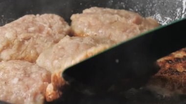 Turning upside down the cooked cutlet rissole.close-up.4K UHD