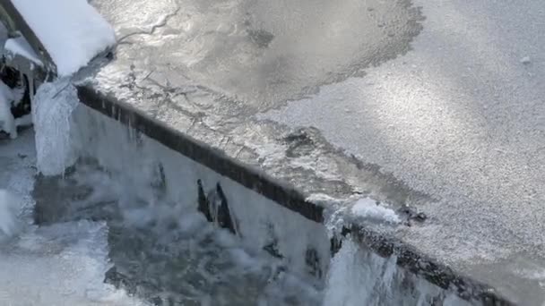 Impressionante colpo di acqua ghiacciata che scorre su una piccola diga durante l'inverno. — Video Stock