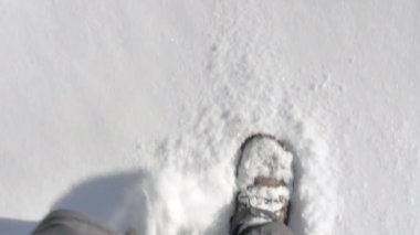 Closer shot of walking through snow on a sunny day.