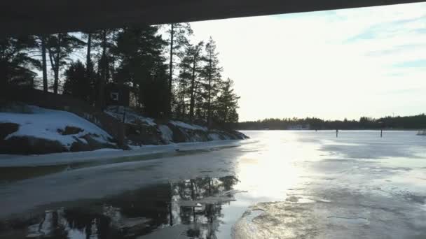 Closer drone shot of the frozen sea under a bridge. — Stock Video