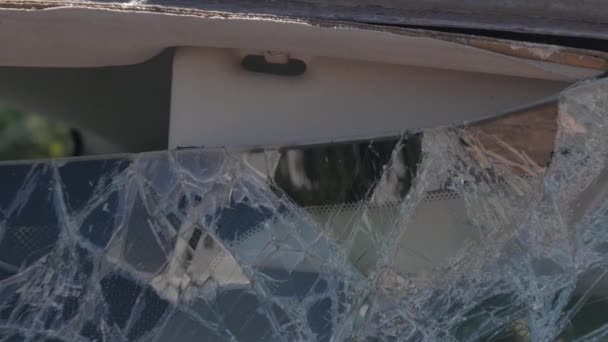 Zdjęcie z bliska przedniej szyby samochodu rozbitej deską. — Wideo stockowe