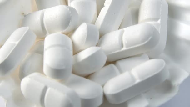 Närbild skott av vita piller på en snäcka med vit bakgrund. — Stockvideo