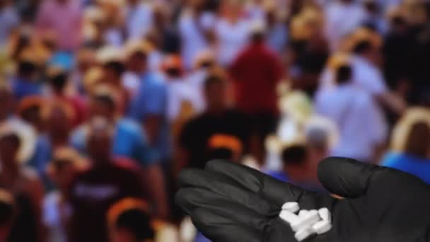 Primer plano de una mano en guantes de látex negro sosteniendo píldoras blancas. — Vídeos de Stock