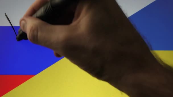 Alguien escribiendo GUERRA sobre la bandera rusa y ucraniana. Invasión rusa de Ucrania — Vídeo de stock