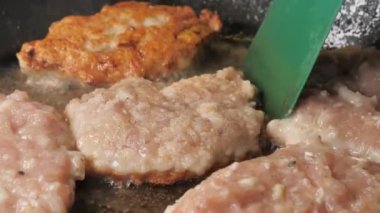 Pirzolanın pişmiş kısmını kızartma panelinin içine çeviriyorum. Yakın çekim UHD.