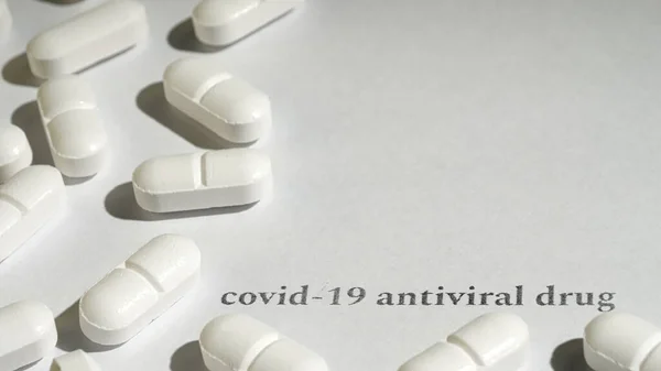 Detailní záběr bílých pilulek na dřevěné ruce. Bílé pozadí. Černý text. — Stock fotografie