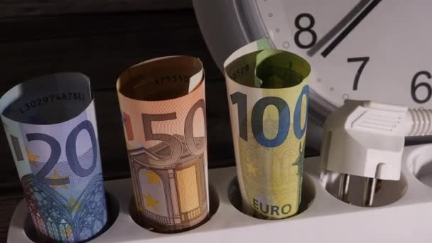 Gros plan de la monnaie sur une prise électrique avec une horloge derrière eux. — Video