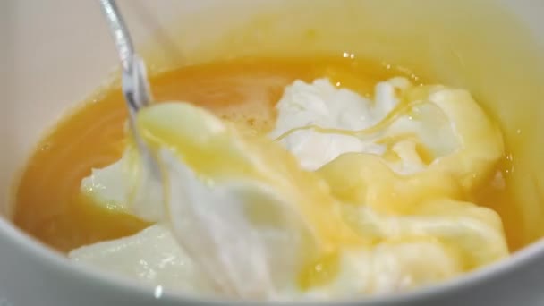 Mieszanie białej śmietany z jajami wewnątrz miseczki. — Wideo stockowe