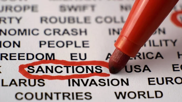 Beyaz kağıda yazılmış SANCTION 'ların yakın çekimleri, etrafında kırmızı bir daire var..