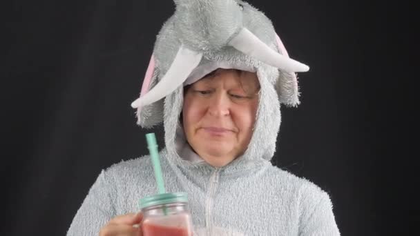 Gros plan d'une dame buvant un smoothie en costume d'éléphant. — Video