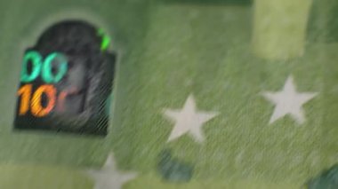 100 Euro nakitin yakın plan çekimi. Kağıt paranın küçük ayrıntıları gösteriliyor. 