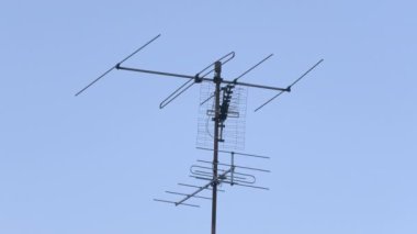 Açık gökyüzü ve arka planda ağaçlar olan bir çatıda inanılmaz anten görüntüsü..