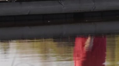 Yüzen bir köprüde oturan orta yaşlı bir kadının yakın çekimi..