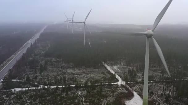 A finnországi erdő szélgenerátorainak közelebbi drónnézőpontja. — Stock videók