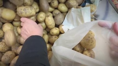 Dükkandaki bir torbaya patates koyarken yakın çekim..