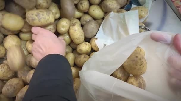 Tiro de close-up de pôr batatas em uma bolsa em uma loja. — Vídeo de Stock