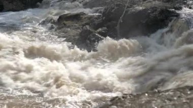 Yakın çekim su küçük bir şelaleden aşağı akıyor..