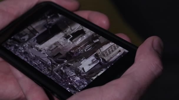 Qualcuno che tiene uno smartphone e guarda un video sulla guerra in Ucraina. — Video Stock