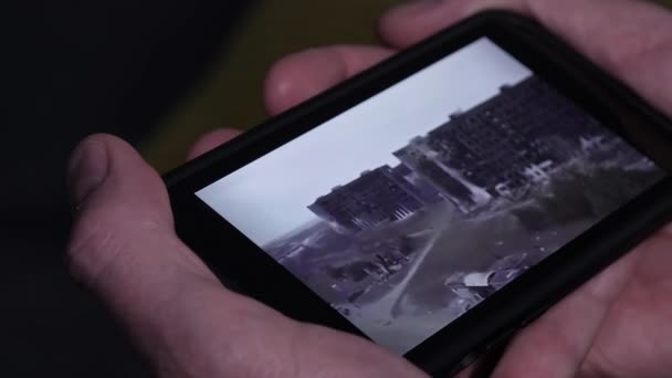 Jemand hält ein Smartphone in der Hand und schaut sich ein Kriegsvideo aus der Ukraine an. — Stockvideo