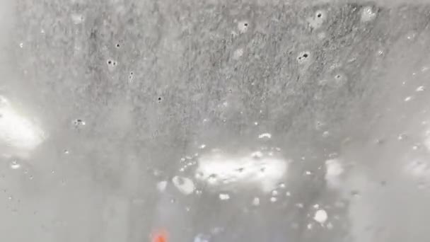 Closeup shot of water flowing down on a car windshield. — Video Stock