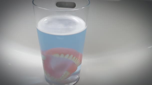 Closeup Shot Artificial Teeth Glass Left Sink Dentures Slowly Being — Stock Video