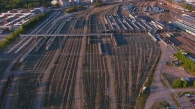 Helsinki. Finlandiya-30 Ağustos 2021: Helsinki Finlandiya 'daki bir demiryolu istasyonunun muhteşem bir bakış açısı. Nakliye aracı. Bir sürü tren yolu var. Kamera geriye ve yukarı doğru hareket ediyor.