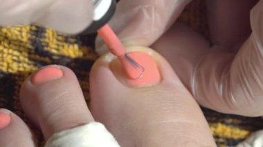 Ev pedikür seansı sırasında ayak parmaklarına pembe oje sürüyorum.