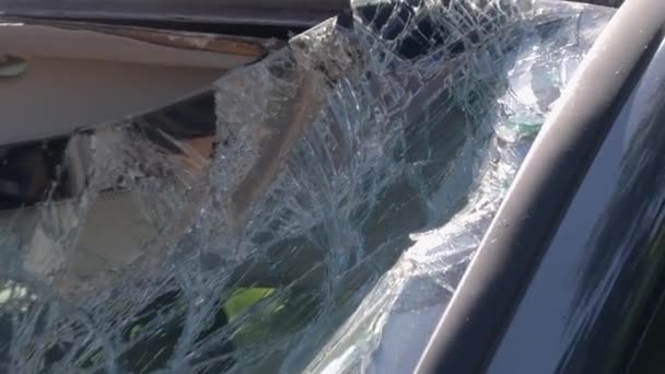 壊れたフロントガラスを示す破壊されている車の閉鎖ショット 板で窓を割った 車が故障した カメラがゆっくりとズームアウト — ストック動画