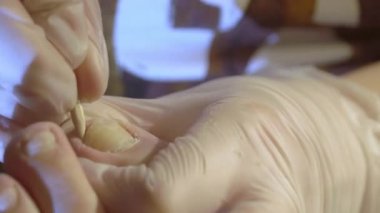 The closer look of getting off the dry skin on the nails of the toes on a pedicure session at home