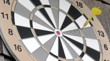 Dart tahtasından sarı dart okunu alan birini yakından çek. İnsan eli. İyi bir eğlence aktivitesi. Eğlenceli oyun ve aynı zamanda bir spor..
